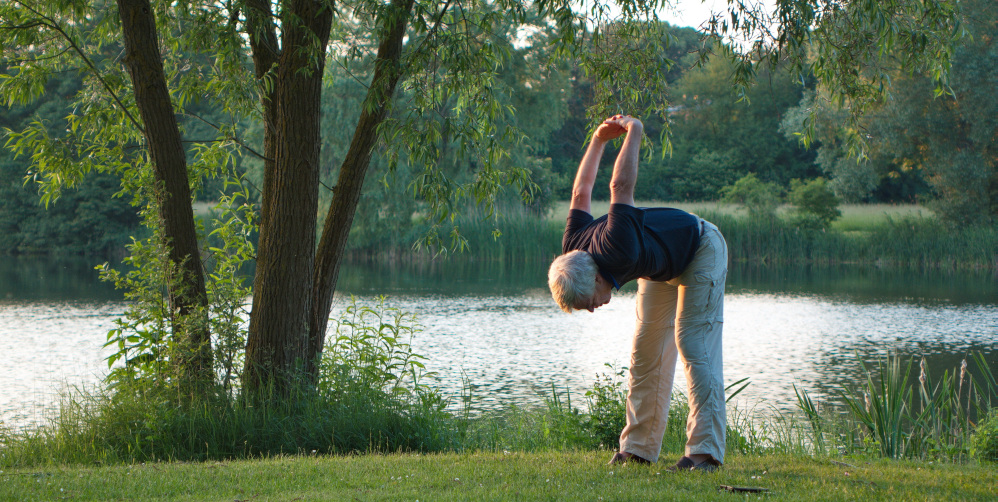 Physiotherapy for seniors in Mississauga – older man doing mobility exercises outdoors